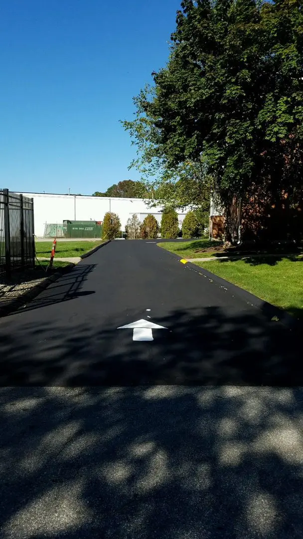 Freshly paved road with traffic arrow stencil ready for painting.